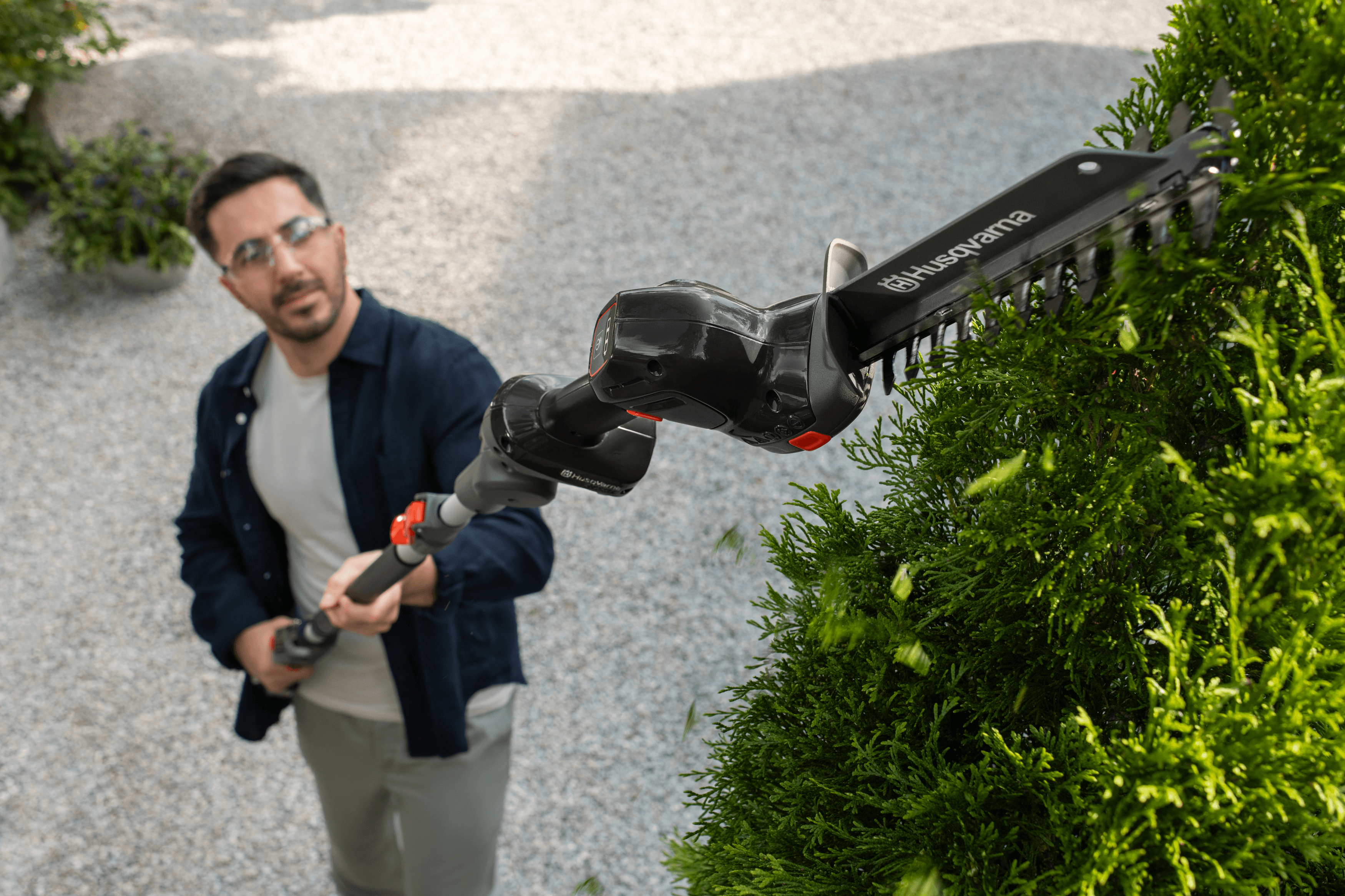 man holding chainsaw whilst cutting tree
